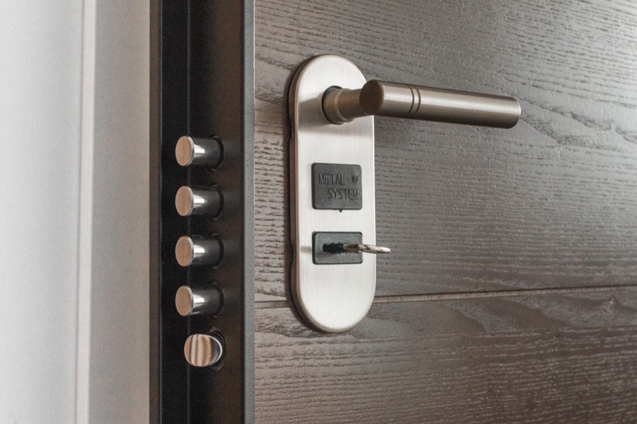 Serrure multipoints moderne posée sur une porte d'entrée en bois